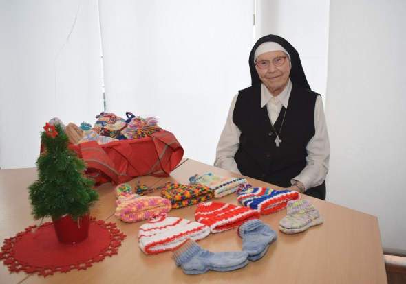 Sr. Philaretha und ihre selbst gestrickte Mützen und Socken.