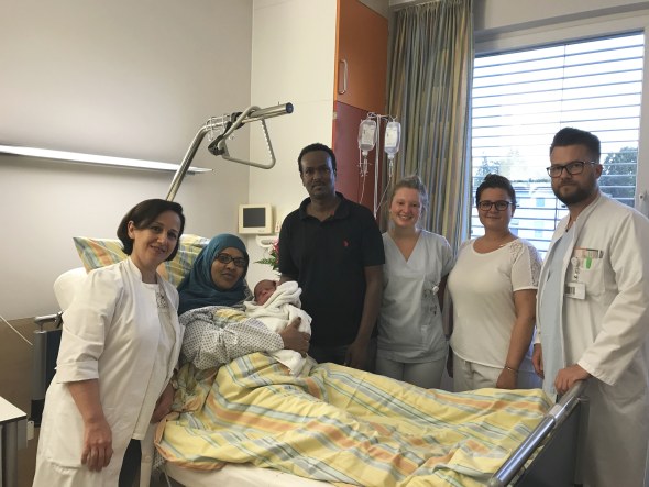 Im Foto von links nach rechts: Oberärztin Z. Ghonoudi, Frau Lula Yasin Shariff mit dem Baby im Arm, Hr. Ahmed Mukhtar, Schwester Michelle, Hebamme Lena Schmidt, Funktionsoberarzt P. Lang