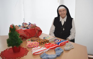 Sr. Philaretha und ihre selbst gestrickte Mützen und Socken.