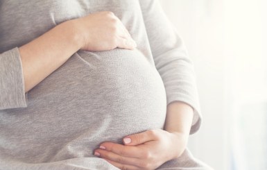 Schwangere Frau hält ihren Bauch