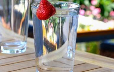 Glas Wasser mit dekorativer Erdbeere