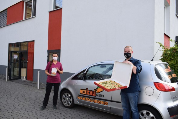 Herr Walch übergibt das Essen an Mitarbeiterin der  Cafeteria